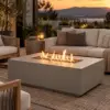 Mist-gray propane fire pit table with linear flame on a patio